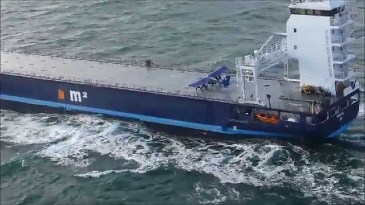 Extreme small plane landing on a ship at sea 